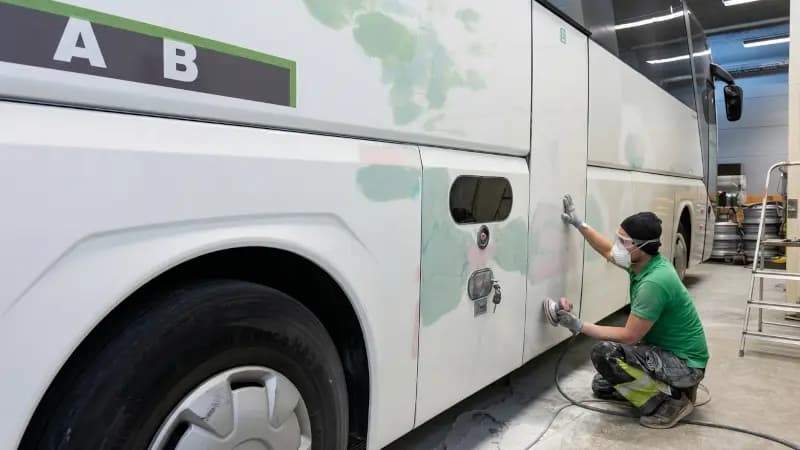 Tekniker slipar och förbereder buss för omlackering i plåtverkstad i Järfälla